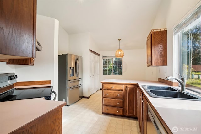 kitchen with appliances with stainless steel finishes, sink, hanging light fixtures, and kitchen peninsula