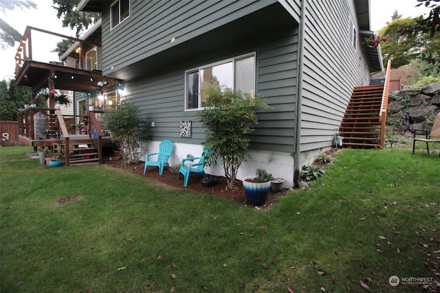 view of side of home with a lawn and a wooden deck