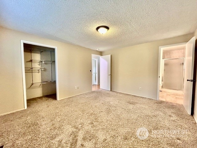 unfurnished bedroom with a closet, light colored carpet, and a textured ceiling