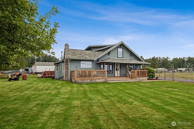 back of house featuring a lawn and a deck