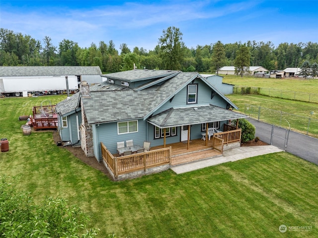 back of property with a wooden deck and a lawn