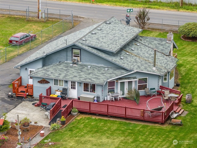 rear view of property with a wooden deck and a lawn