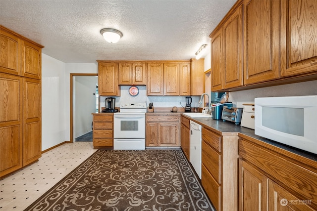 kitchen featuring a textured ceiling, sink, and white appliances