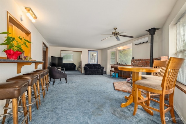 dining space with carpet, a wall mounted AC, a wood stove, and ceiling fan