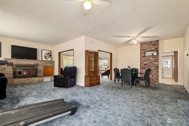 carpeted living room featuring ceiling fan and a textured ceiling