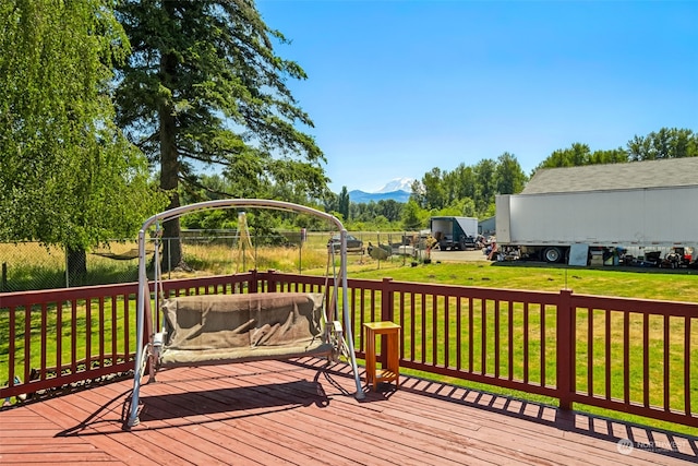 wooden terrace with a mountain view and a lawn