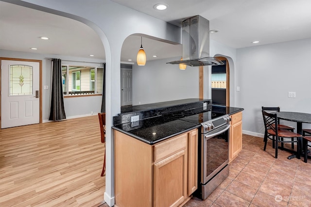 kitchen featuring light brown cabinets, stainless steel electric range, island range hood, pendant lighting, and light hardwood / wood-style floors