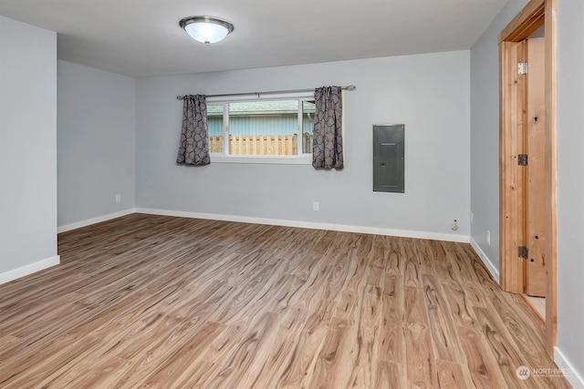 unfurnished room featuring light hardwood / wood-style flooring and electric panel