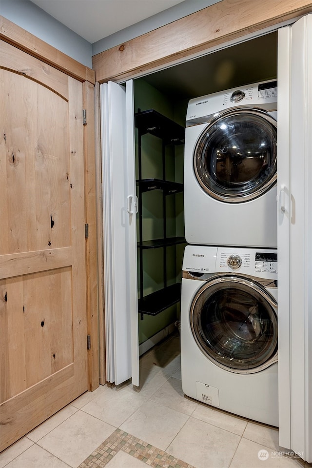 washroom featuring stacked washer / dryer and light tile patterned floors