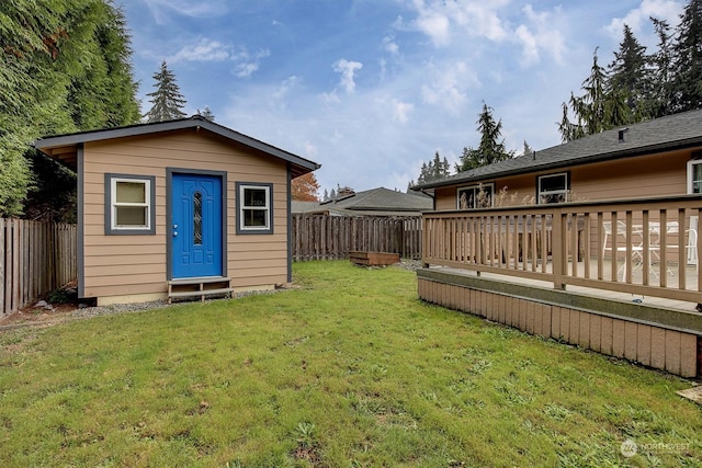 back of house featuring a yard, a storage shed, and a deck