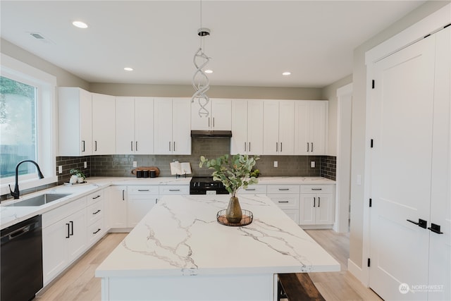 kitchen featuring black appliances, sink, pendant lighting, and a kitchen island