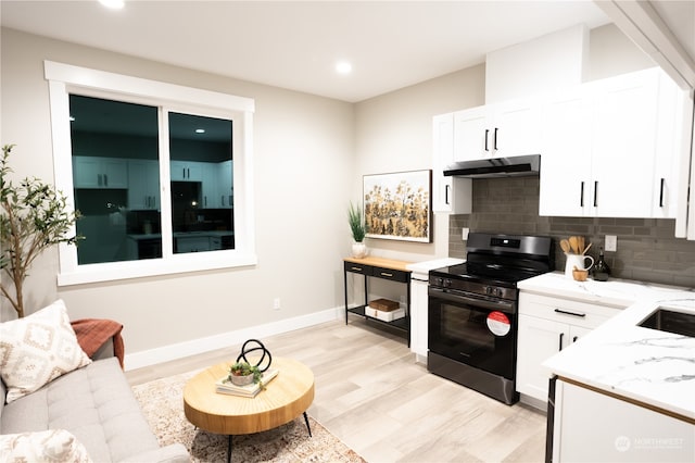 kitchen featuring tasteful backsplash, black gas range, white cabinetry, light hardwood / wood-style floors, and light stone counters