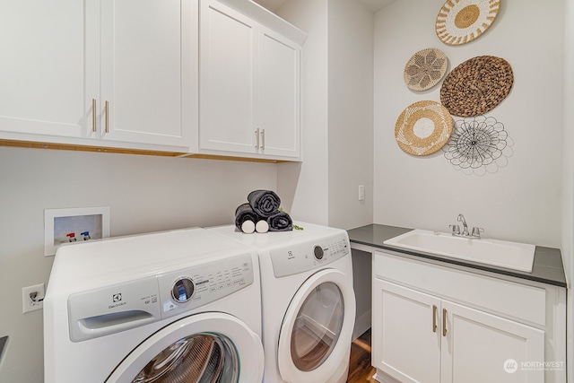 laundry area with washer and dryer, sink, and cabinets