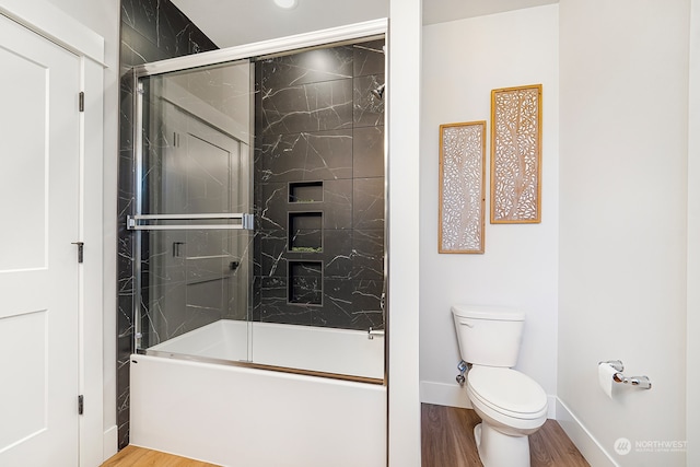 bathroom featuring combined bath / shower with glass door, toilet, and wood-type flooring