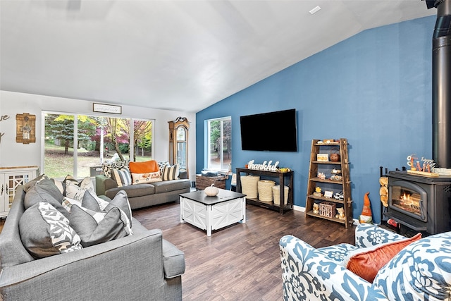 living room featuring dark wood-type flooring, vaulted ceiling, and a wood stove