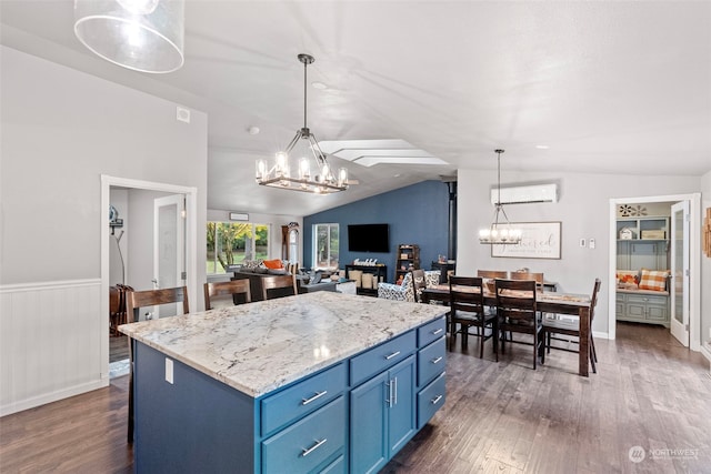 kitchen featuring lofted ceiling, blue cabinets, hanging light fixtures, and dark hardwood / wood-style flooring