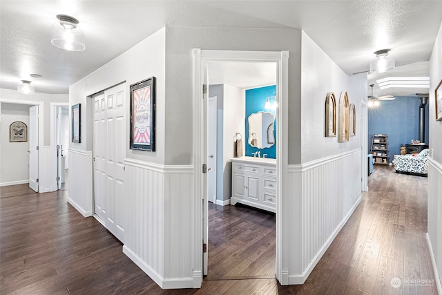 hallway featuring a textured ceiling and dark hardwood / wood-style flooring