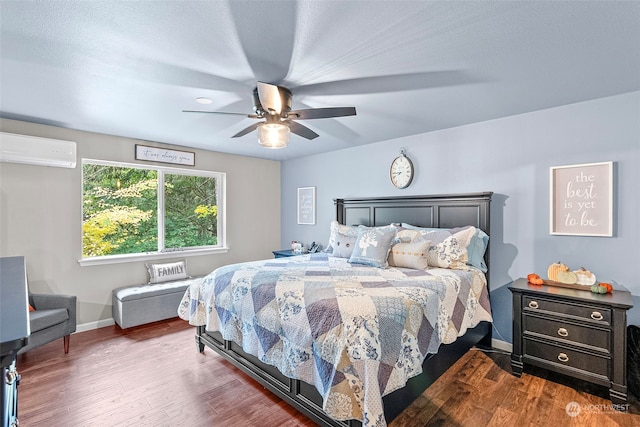 bedroom with dark wood-type flooring, ceiling fan, and a wall mounted AC