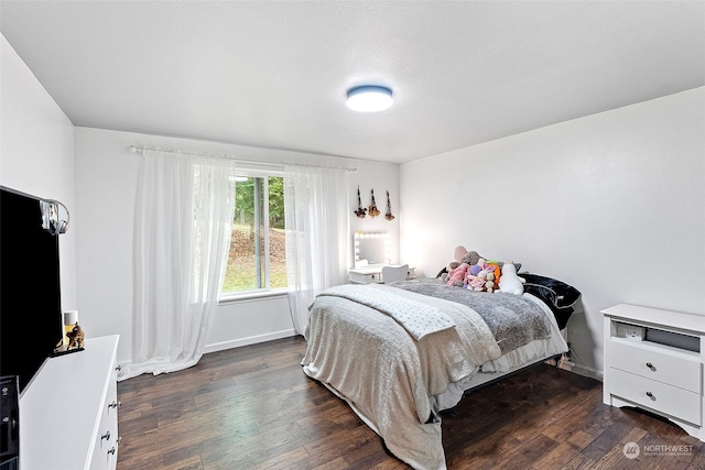 bedroom with dark hardwood / wood-style floors