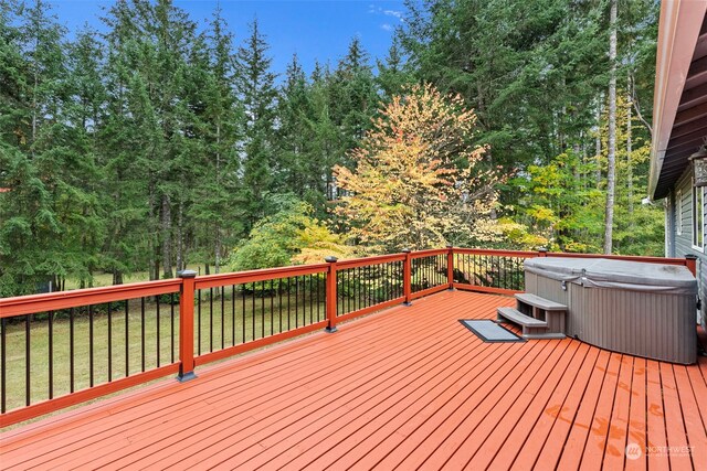 wooden deck featuring a yard and a hot tub