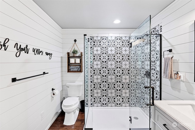 bathroom with toilet, vanity, a shower with shower door, and wood-type flooring