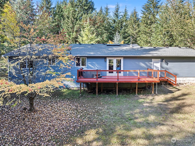 back of property featuring a deck and a lawn