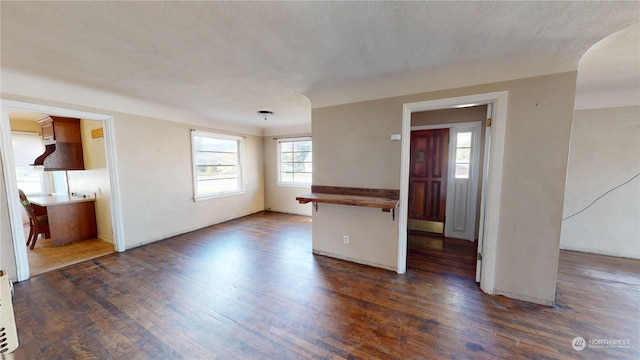 empty room featuring dark wood-type flooring and a textured ceiling