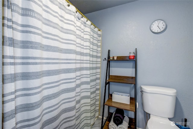 bathroom featuring a shower with curtain and toilet