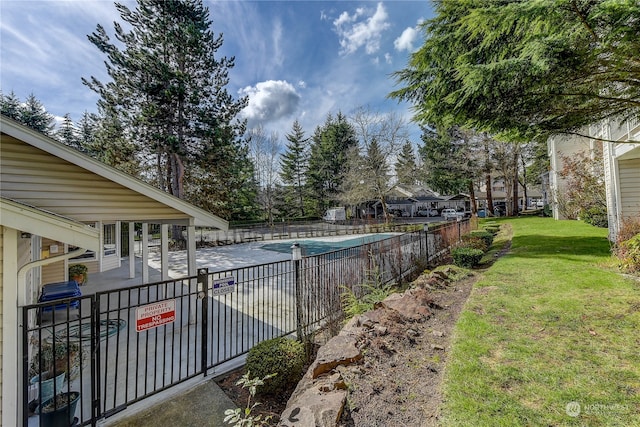 view of swimming pool featuring a yard and a patio