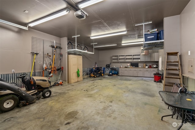 garage with a garage door opener and a workshop area