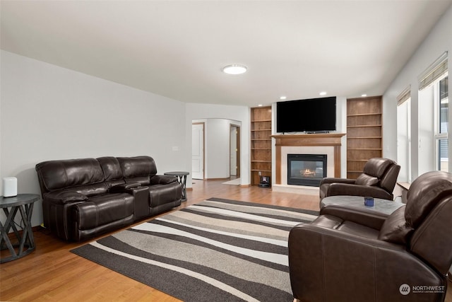 living room with light wood-type flooring and built in shelves