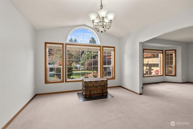 interior space featuring lofted ceiling, a chandelier, and light carpet