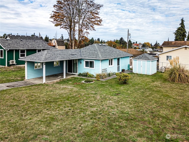 rear view of house with a storage unit, a yard, and a patio area