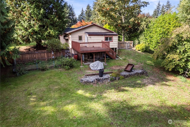 back of property featuring a wooden deck and a lawn