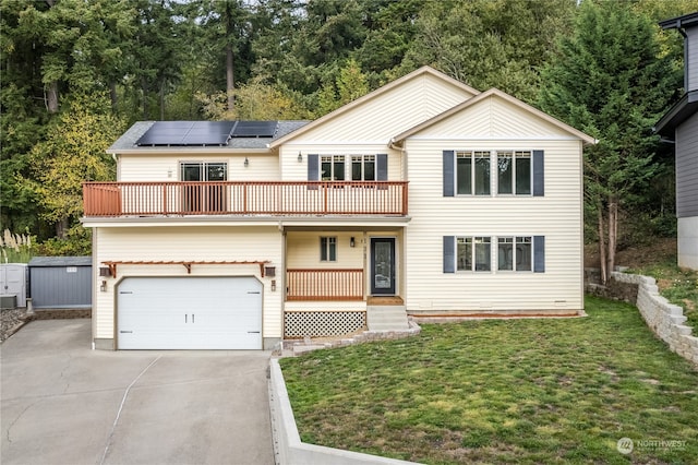 view of property with solar panels, a front yard, a garage, and a balcony