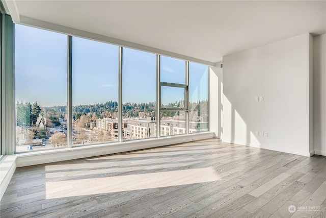 spare room with wood-type flooring and plenty of natural light