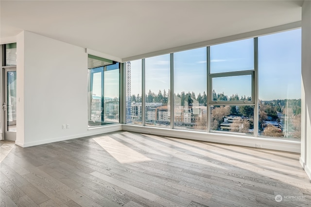 unfurnished room featuring hardwood / wood-style floors and a healthy amount of sunlight