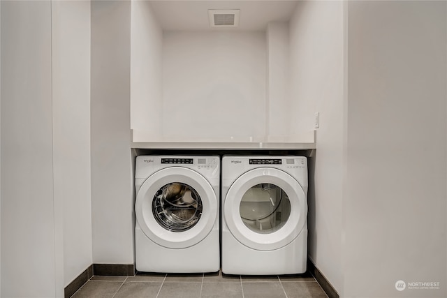 laundry room featuring washing machine and dryer and tile patterned flooring