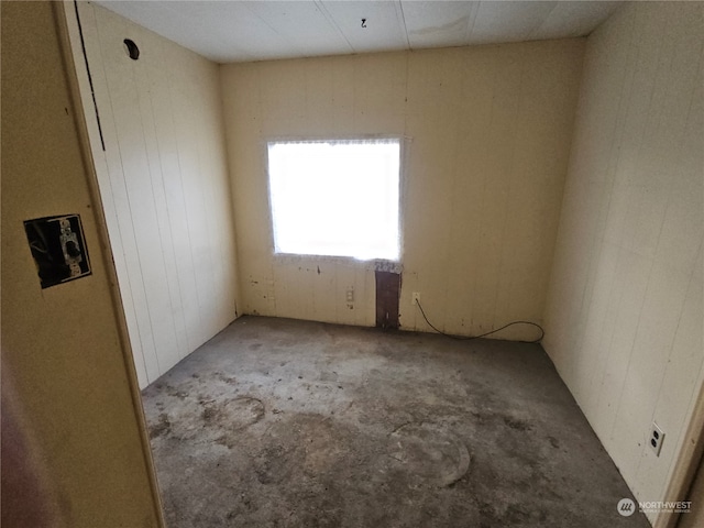 carpeted spare room with wooden walls