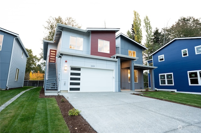 contemporary home with a front yard and a garage