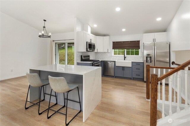 27705 23rd Ave S, Federal Way, WA 98003 - kitchen with light wood-type flooring, appliances with stainless steel finishes, tasteful backsplash, and a sink