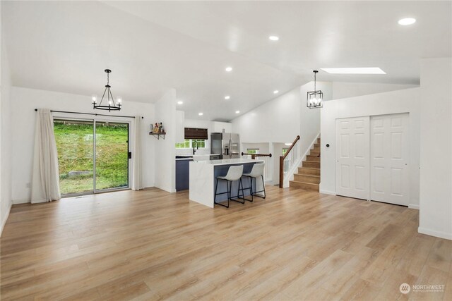 27705 23rd Ave S, Federal Way, WA 98003 - kitchen with an inviting chandelier, a kitchen bar, stainless steel refrigerator with ice dispenser, vaulted ceiling, and light countertops