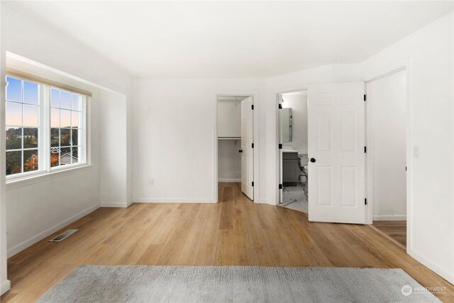 27705 23rd Ave S, Federal Way, WA 98003 - unfurnished bedroom featuring a walk in closet, baseboards, light wood-type flooring, and visible vents