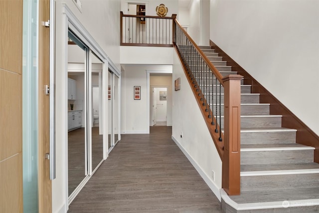 stairs with a high ceiling and wood-type flooring