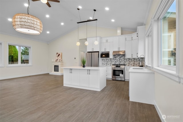 kitchen featuring white cabinets, light wood-type flooring, vaulted ceiling, crown molding, and stainless steel appliances