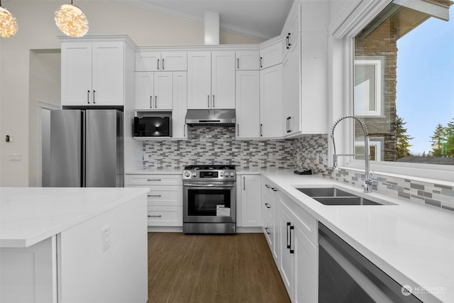 kitchen featuring white cabinets, appliances with stainless steel finishes, vaulted ceiling, sink, and decorative light fixtures