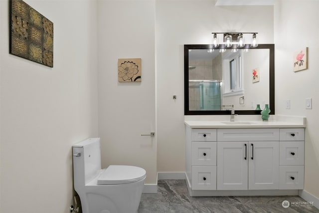 bathroom with vanity, toilet, and a shower with shower door