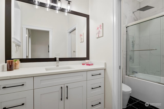 full bathroom featuring vanity, bath / shower combo with glass door, and toilet