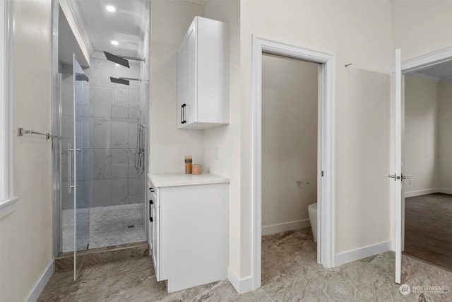 bathroom featuring toilet, crown molding, and a shower with door