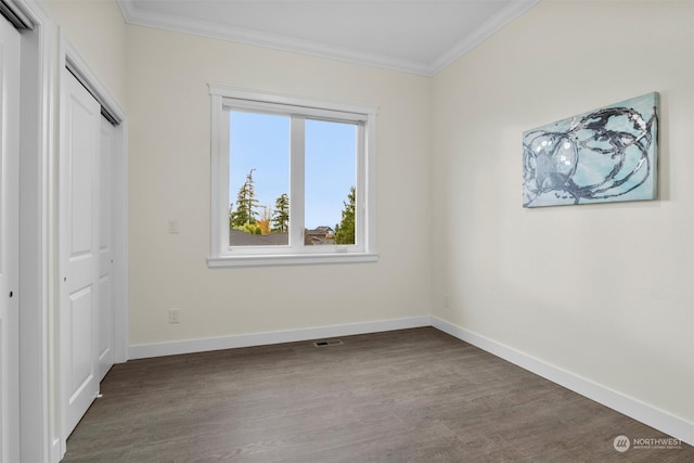 unfurnished bedroom with a closet, crown molding, and hardwood / wood-style floors